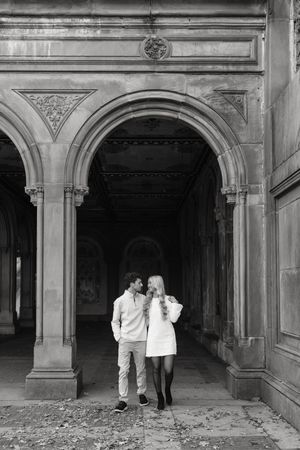 Black and white photo sequence showing figures walking through ornate stone archways in a historic building interior.
