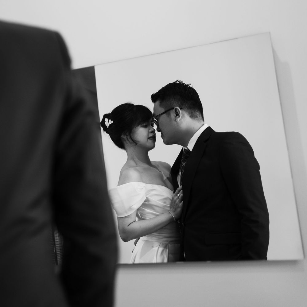 A romantic black and white portrait of a bride and groom in an intimate moment.