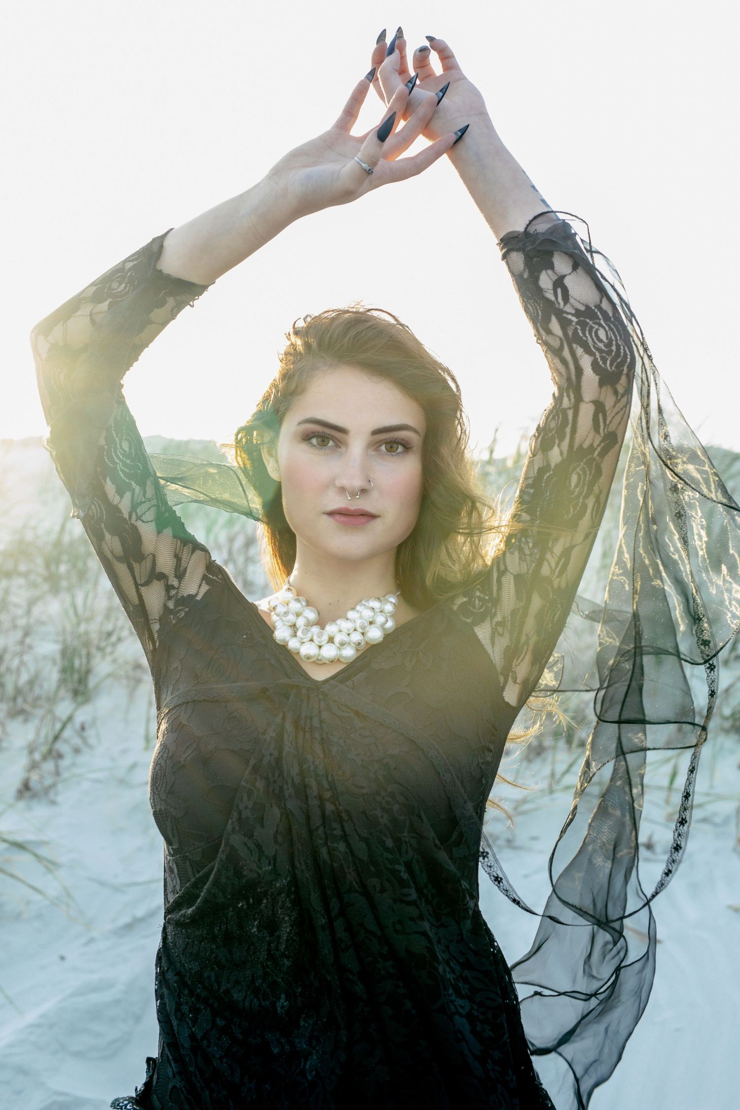 Beach portrait session of woman in romantic black dress and long hair, captured in Amherstburg at golden hour.