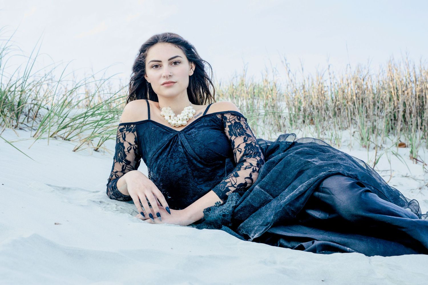 Romantic beach photo of a woman in black dress at sunset, graceful and serene – Essex County photographer.