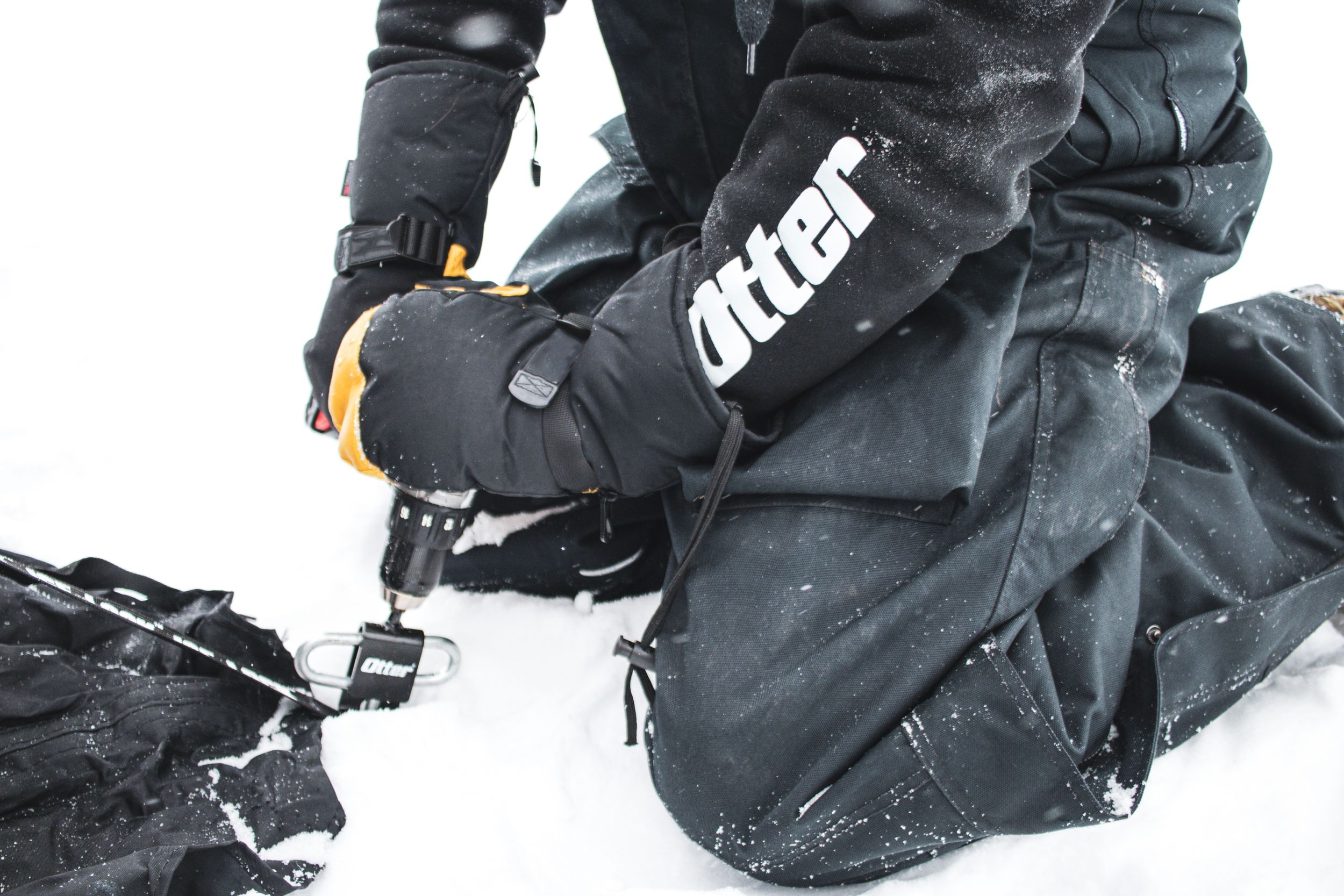 Close-up of black winter gear with Killer logo on snowy ground.