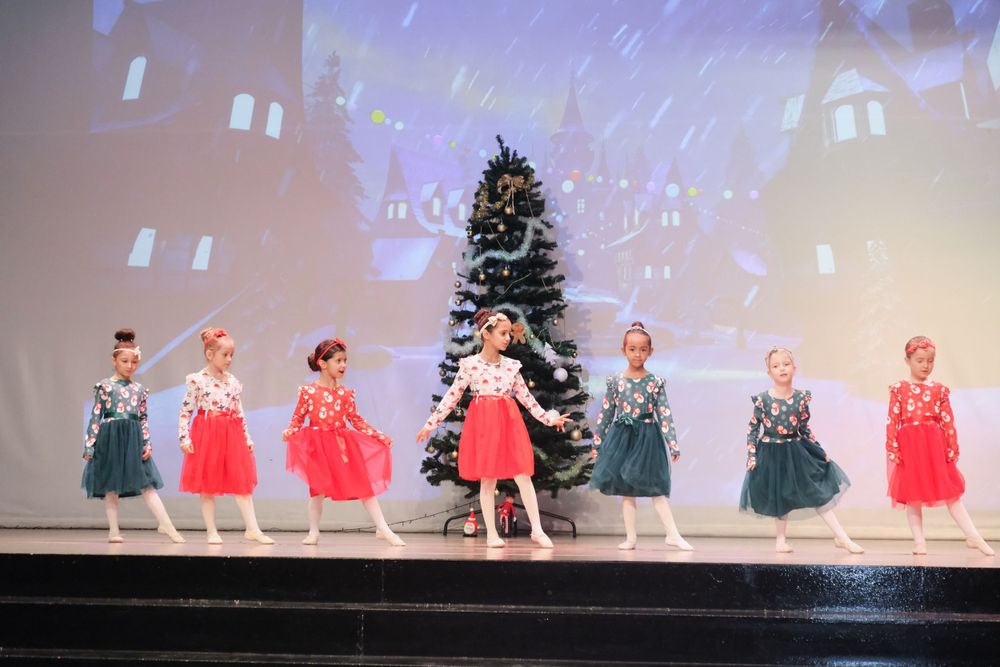 Children dancing on school stage during colorful event photography in Dubai