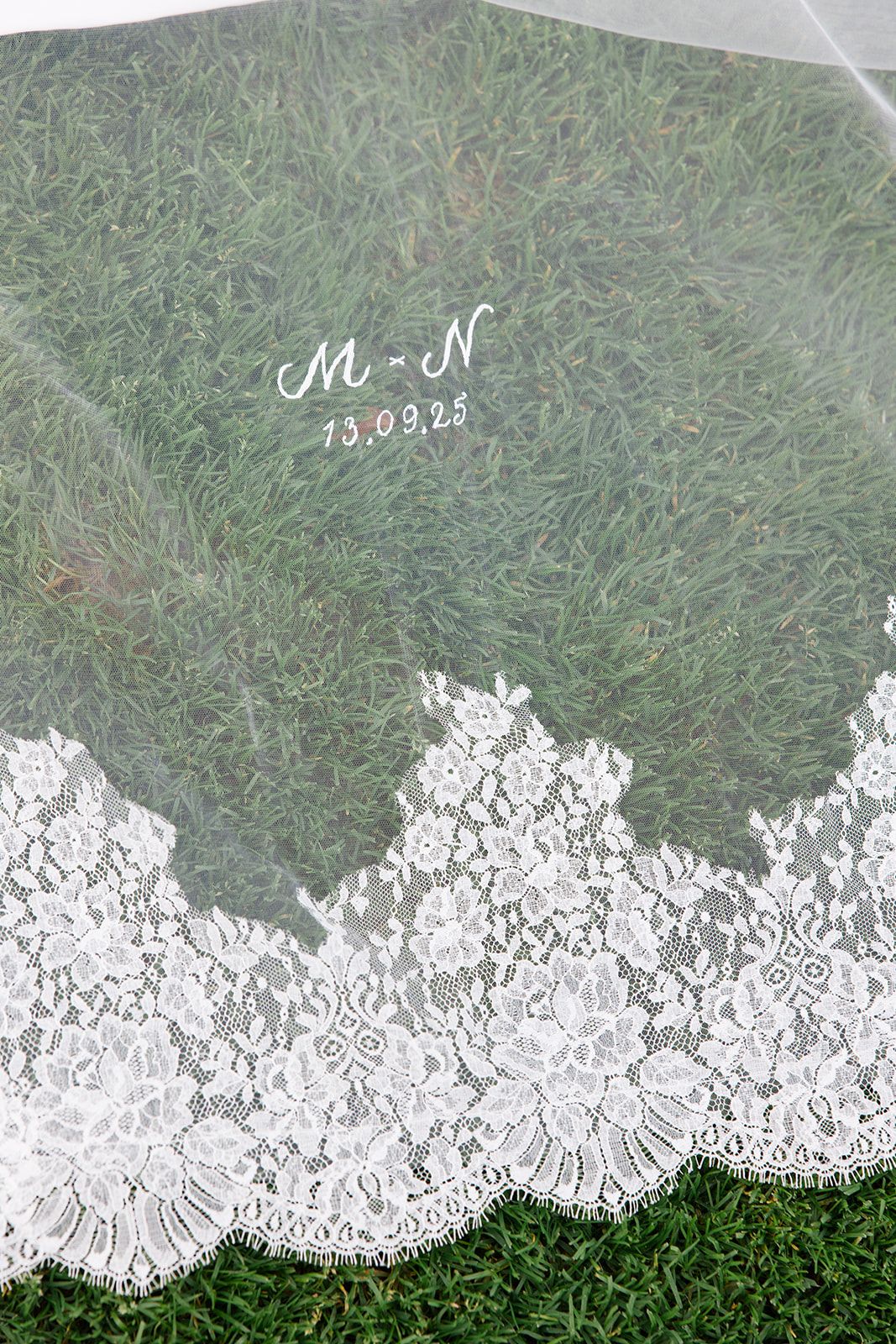 White lace trim decoratively laid out against a green grass background creates an elegant contrast pattern.