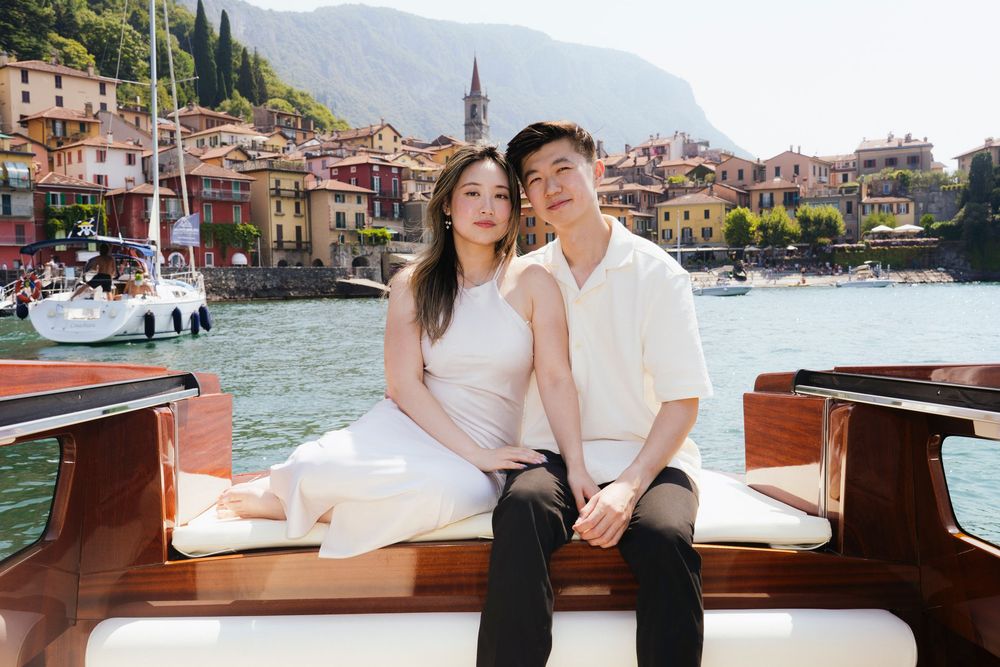 Couple enjoying a romantic boat ride along the scenic canals of Venice with historic architecture in the background.