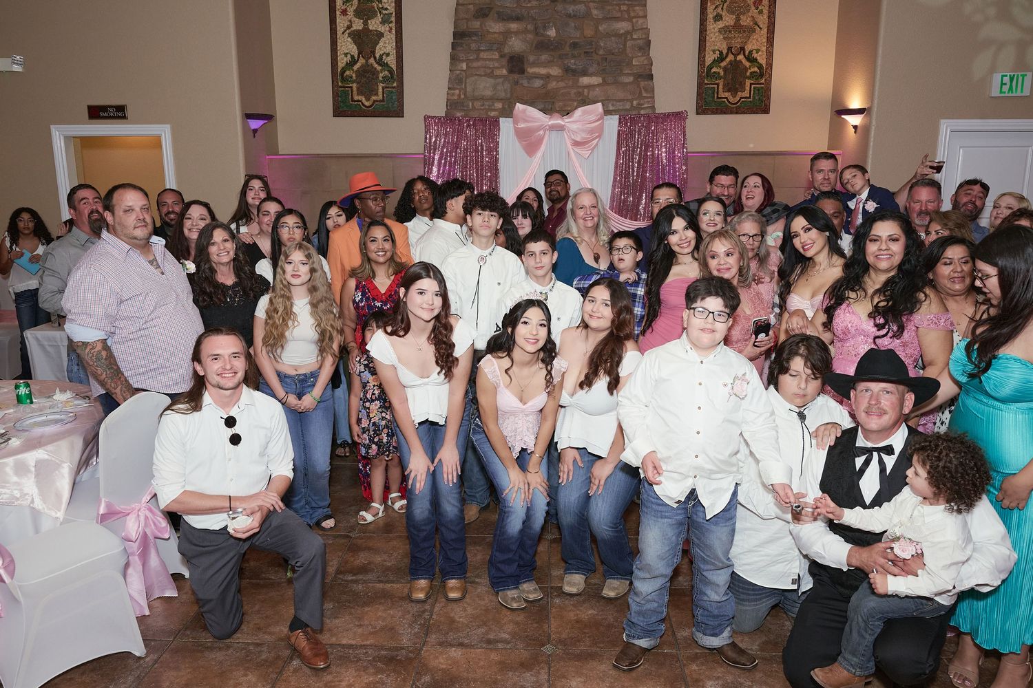 A panoramic collage of people gathered in an indoor venue with stone walls and pink decorative elements.