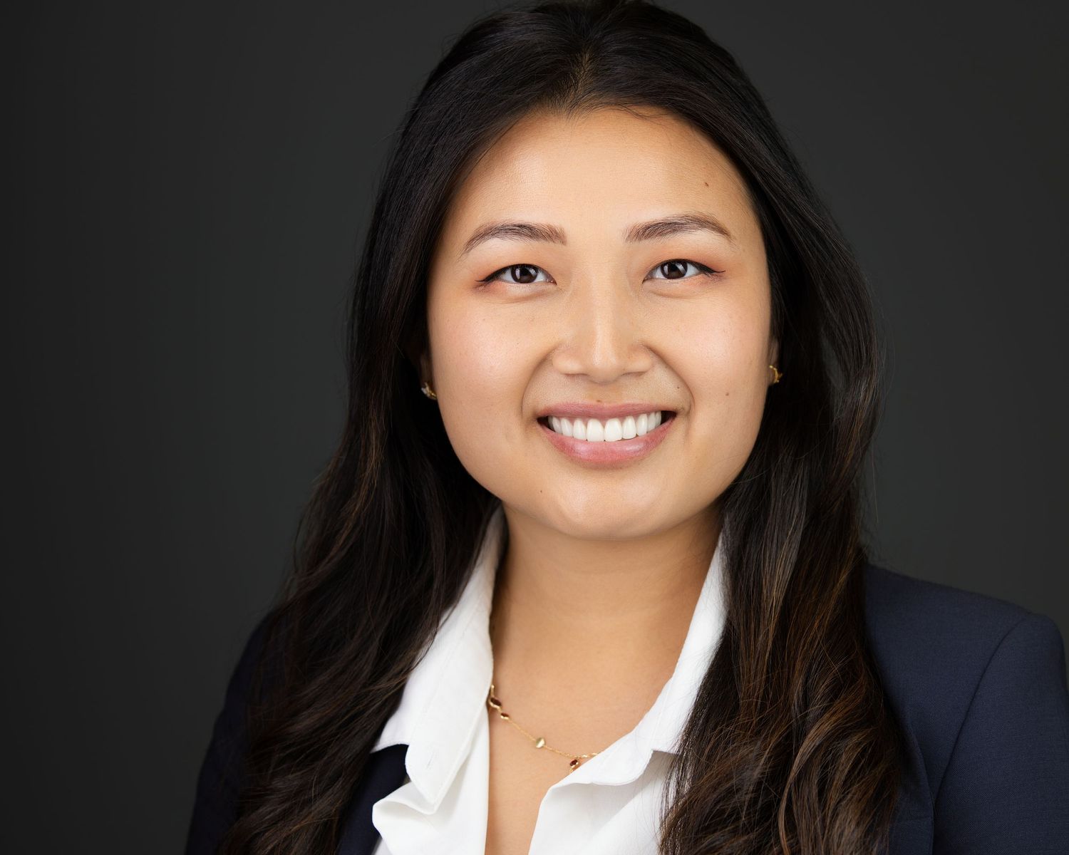 Professional headshot series showing different expressions and poses in front of a neutral studio backdrop.
