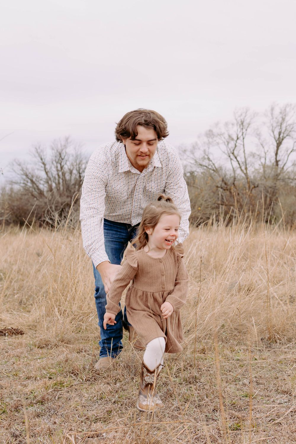 True West Photography - Parent and child play together in field during outdoor family photo session.