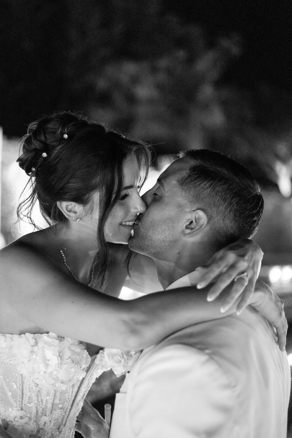 Black and white romantic photograph series showing a couple sharing intimate kisses and tender moments.