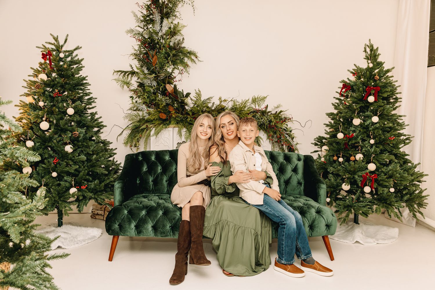 Christmas family pictures of a family of 3 sitting down in an indoor studio in Greeley Colorado. pictures of 2 kids and a mother smiling
