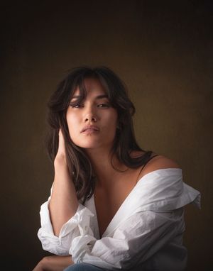 Artistic portrait series showing dramatic angles in white clothing against a dark moody background.