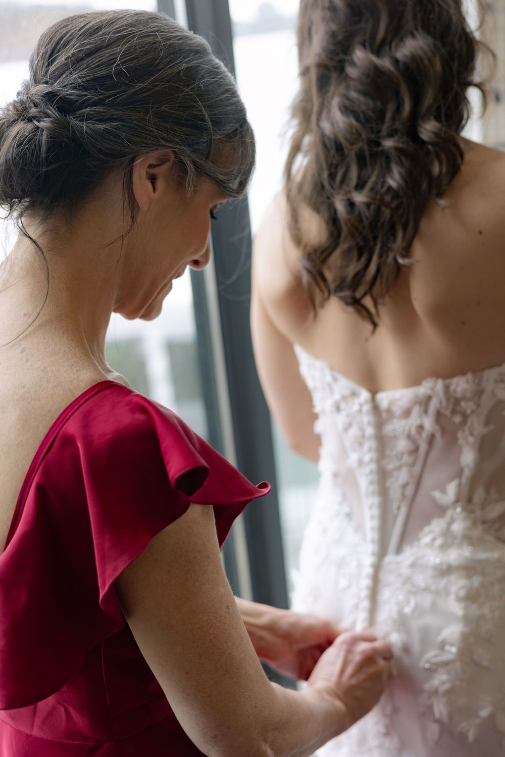 A series of getting ready moments showing someone in a red dress helping with a white wedding gown.