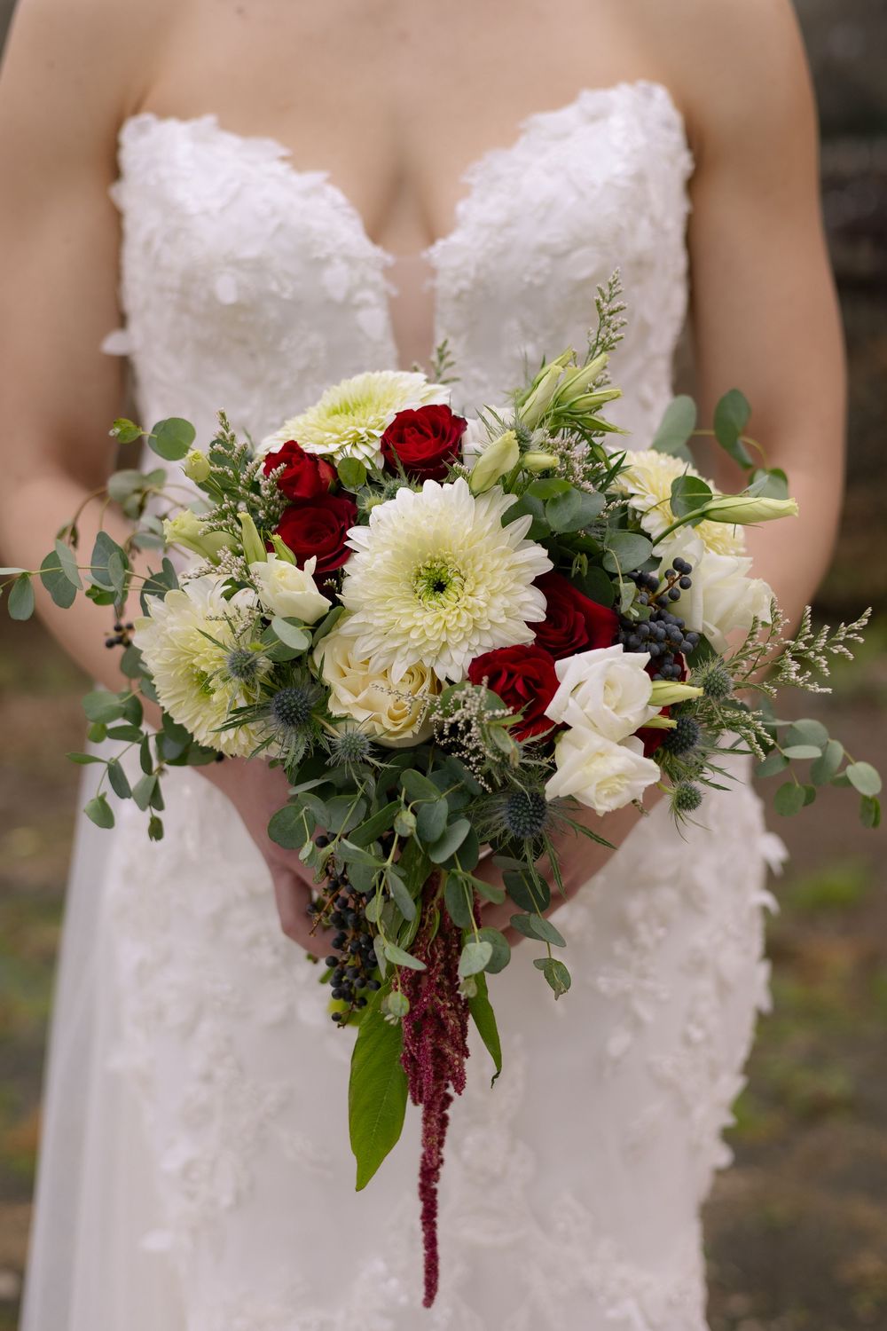Elegant wedding bouquets featuring white and burgundy flowers with cascading greenery against a bridal gown.