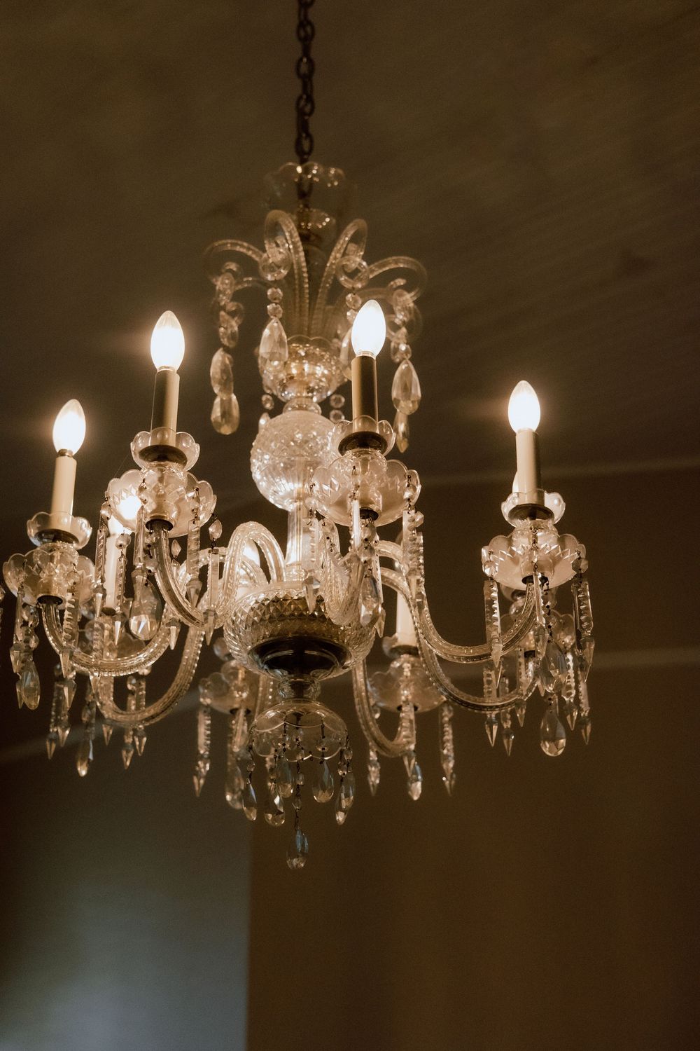 Crystal chandelier with multiple tiers and candle-style lights creates an elegant ambiance.