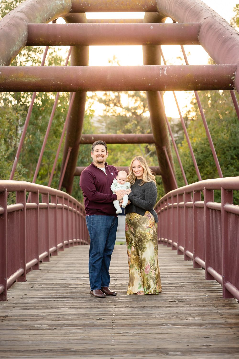 Family portrait with a baby on a bridge during golden hour sunset in Bay Area, California