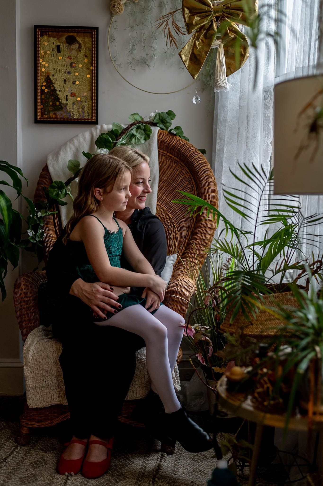 Peaceful indoor scene with wicker peacock chair, houseplants, and soft natural lighting by a window.
