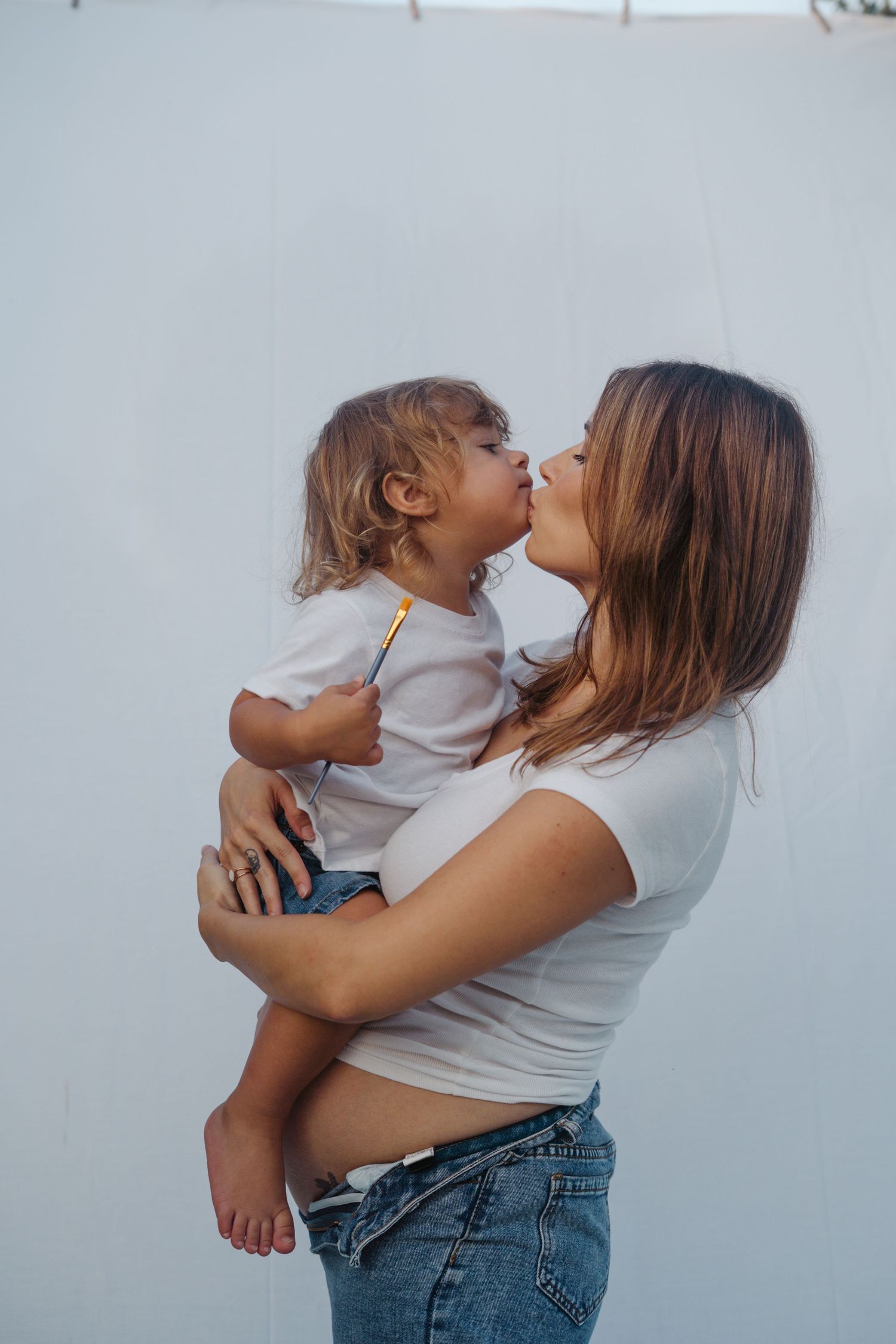 Maternity session outdoors with siblings, playful paint, colorful family photos, natural light, candid moments, lifestyle photography.