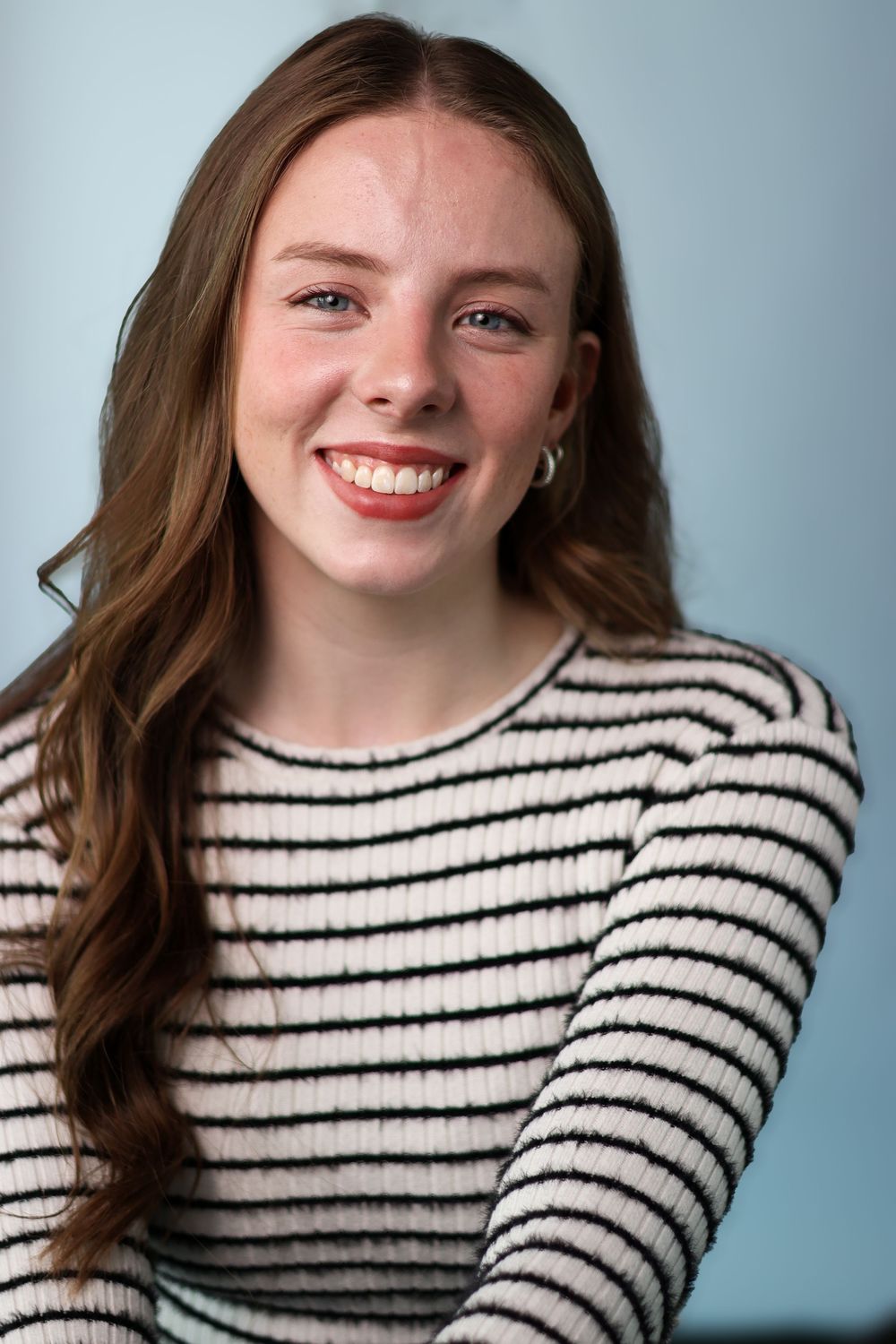 A person wearing a black and white striped sweater poses against a blue background in a series of candid shots.
