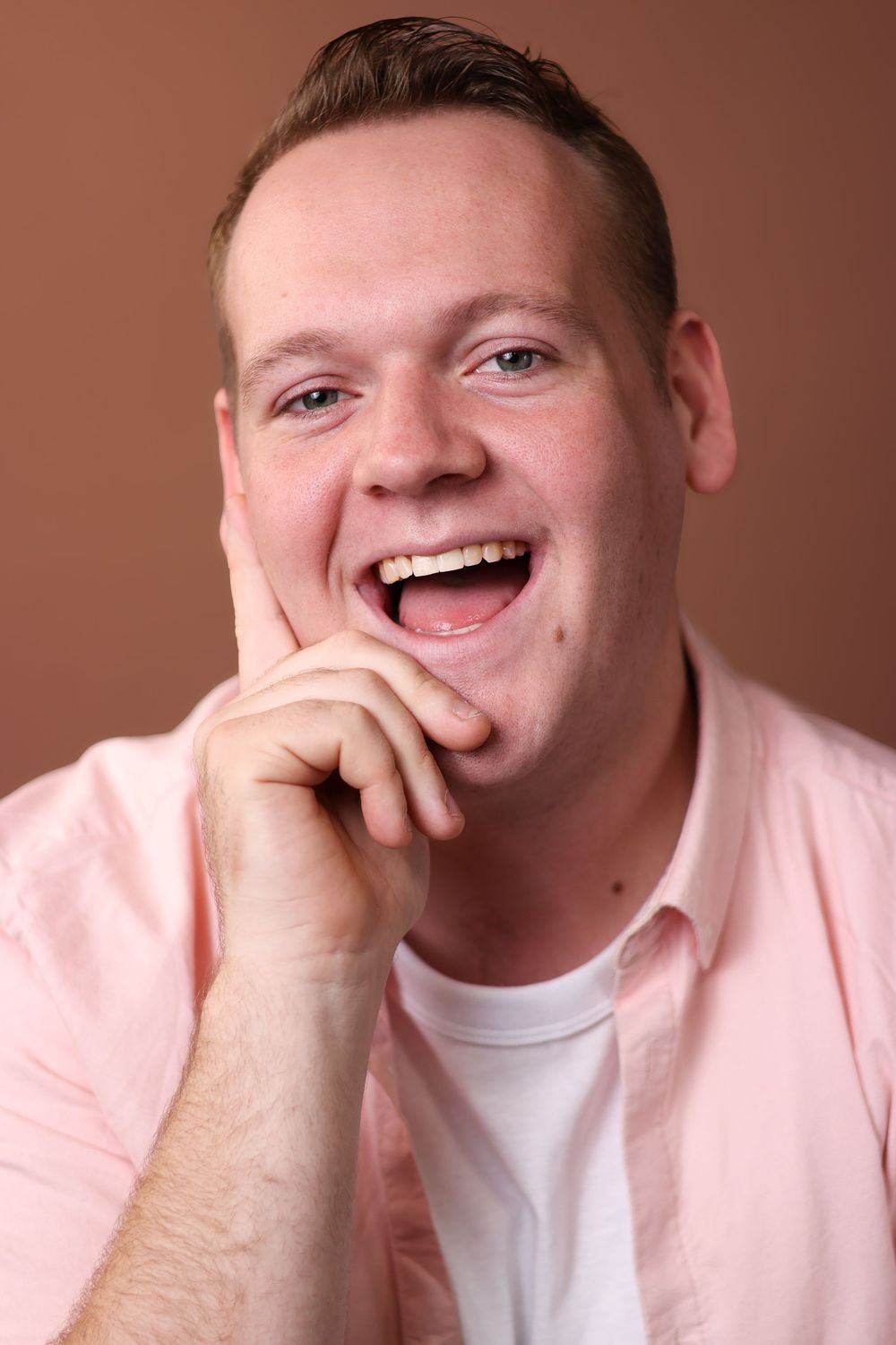 A sequence of four photos showing someone in a pink sweater and white shirt laughing and covering their mouth.