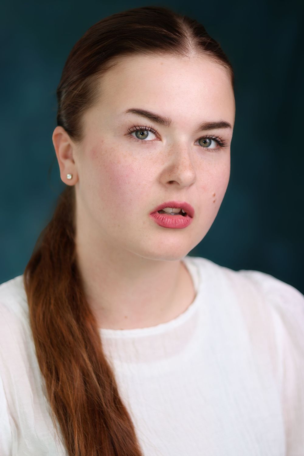 Studio portrait series showing expressive close-up shots against a dark teal background.