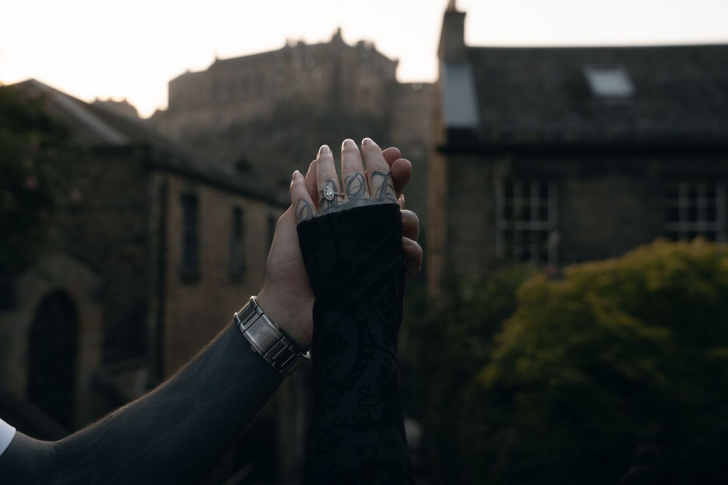 A dramatic black and white silhouette of a person holding their hand up against a dark urban background.