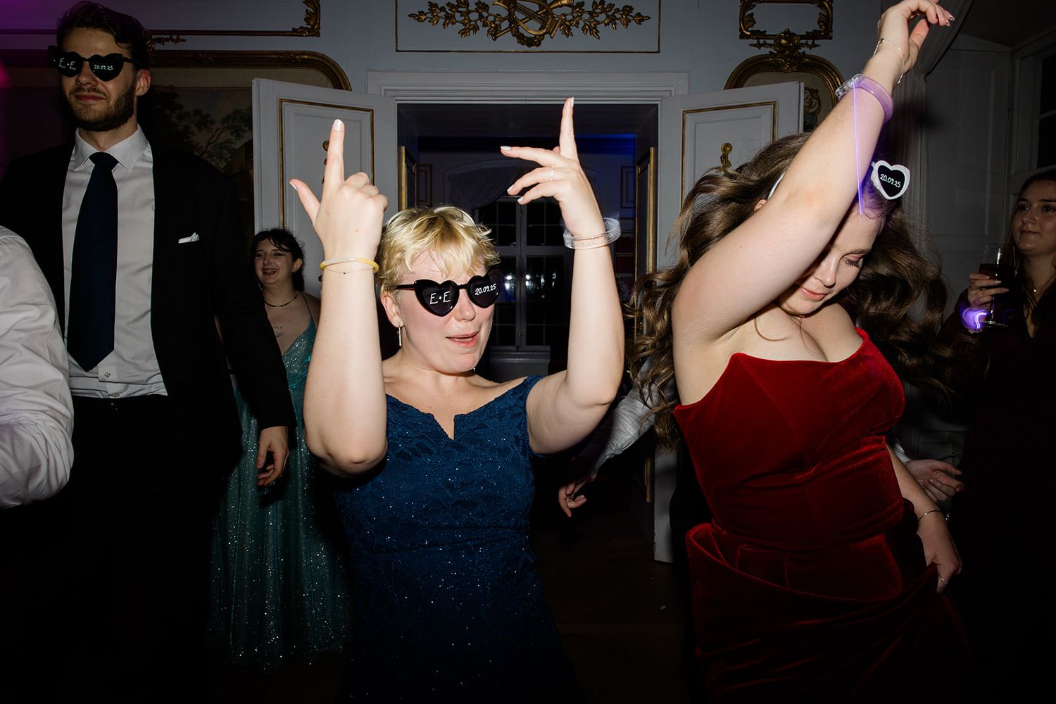 People dancing and socializing at a dimly lit party or nightclub event.
