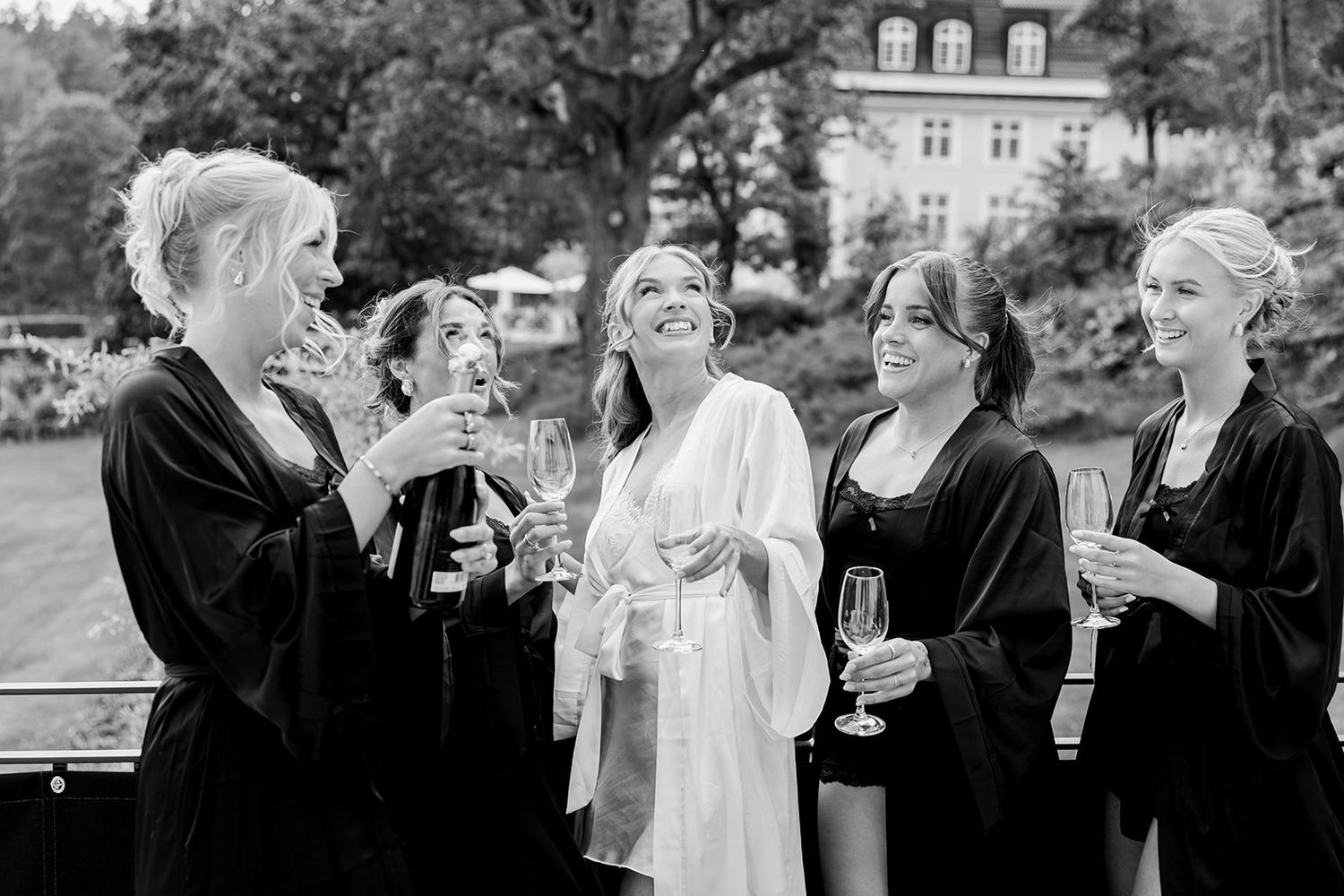 A black and white photo sequence showing wedding guests mingling and enjoying drinks at an outdoor reception.