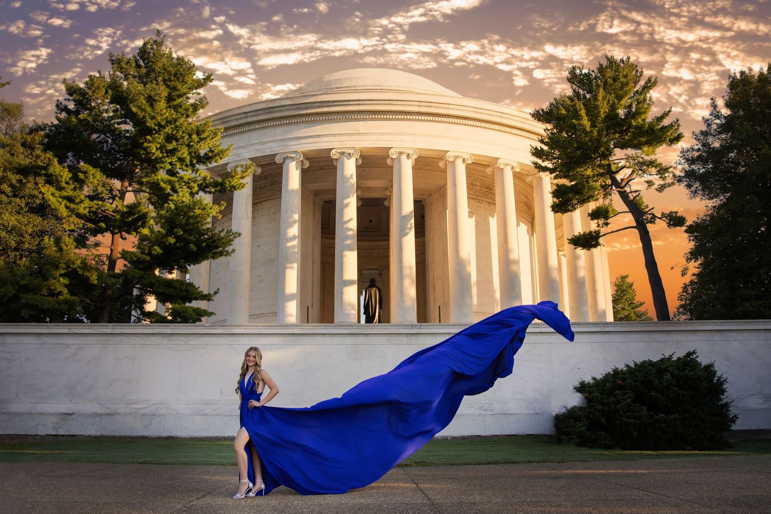 Flying Dress flowing fuchsia gown creates a dramatic silhouette against a sunset-lit reflecting pool at the National Mall in Washington DC.