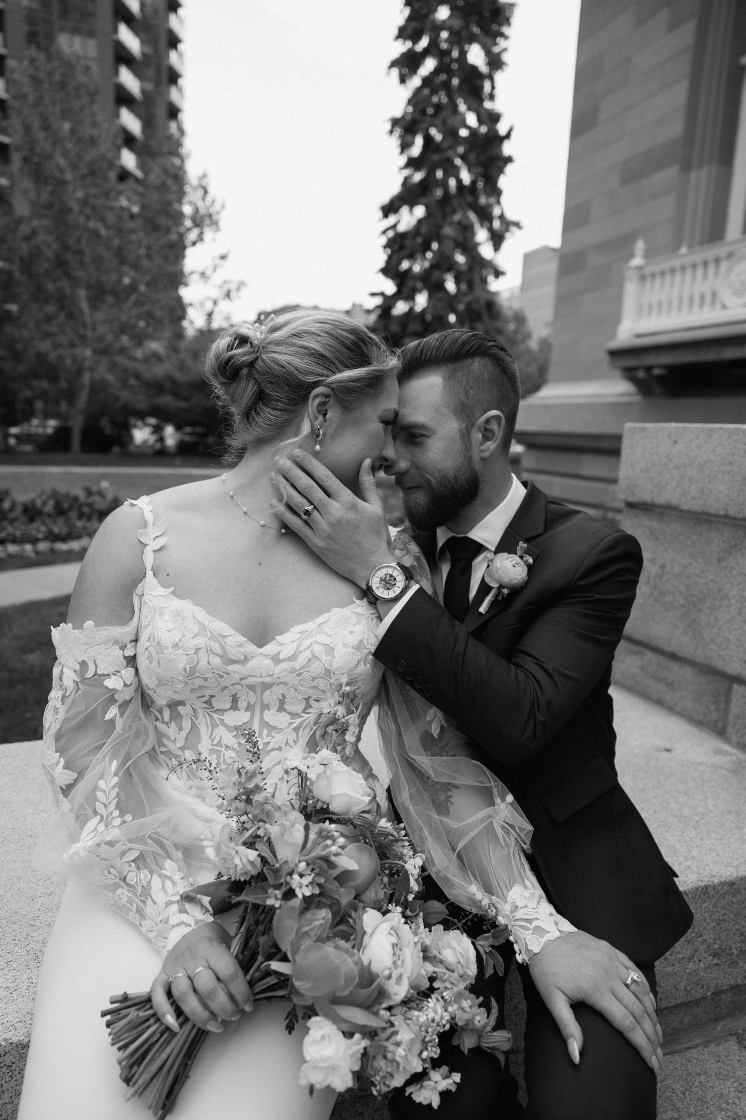 A romantic black and white wedding photo sequence showing a tender kiss with a beautiful floral bouquet.