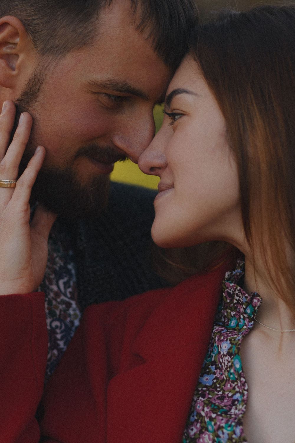 A romantic couple shares an intimate moment against a dark background with soft lighting.