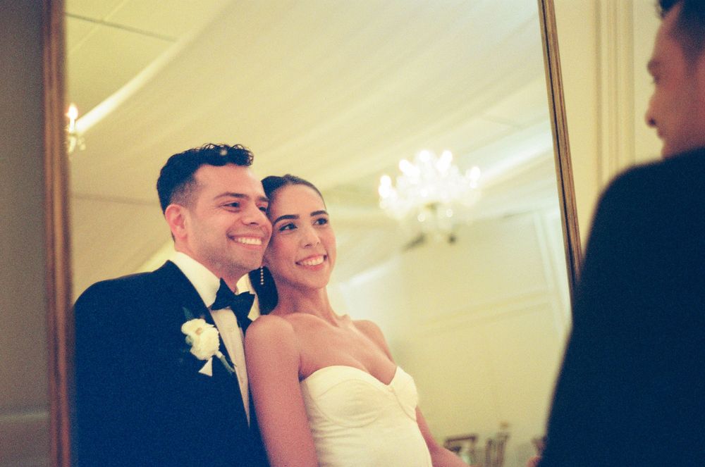 Romantic wedding couple shares an intimate moment while dancing together in an elegant ballroom setting.