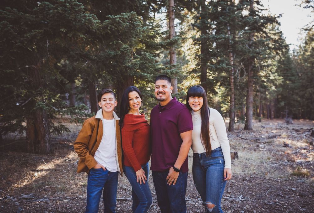 Group walking together through a scenic wooded forest area in autumn light during family photos in the inland empire