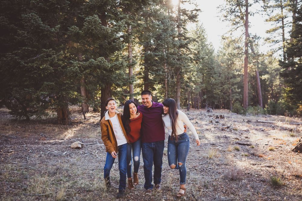 People walking together on a wooded mountain trail during golden hour.