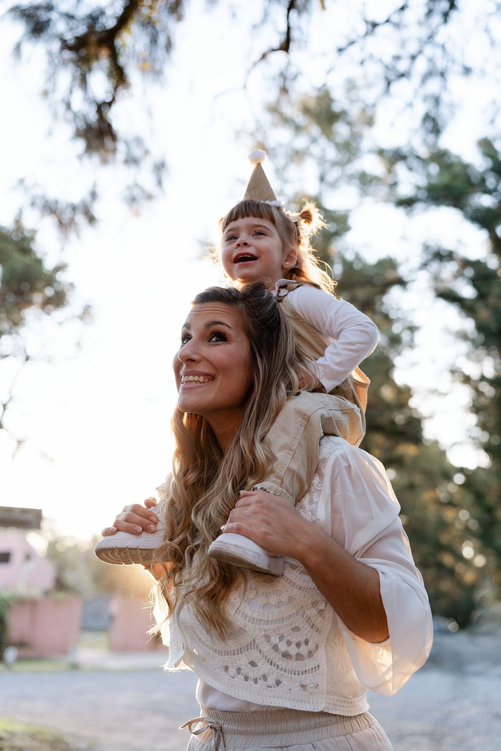 Mother and young child sharing joyful moments together outdoors in soft natural lighting.