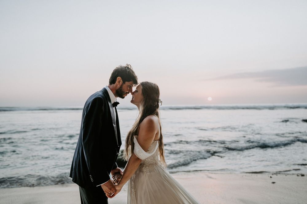 Romantic sunset wedding photography session along a misty oceanfront.