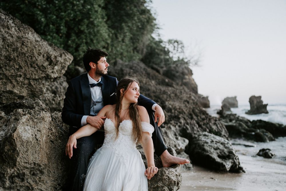 Coastal wedding photography featuring dramatic cliffside views and crashing waves.