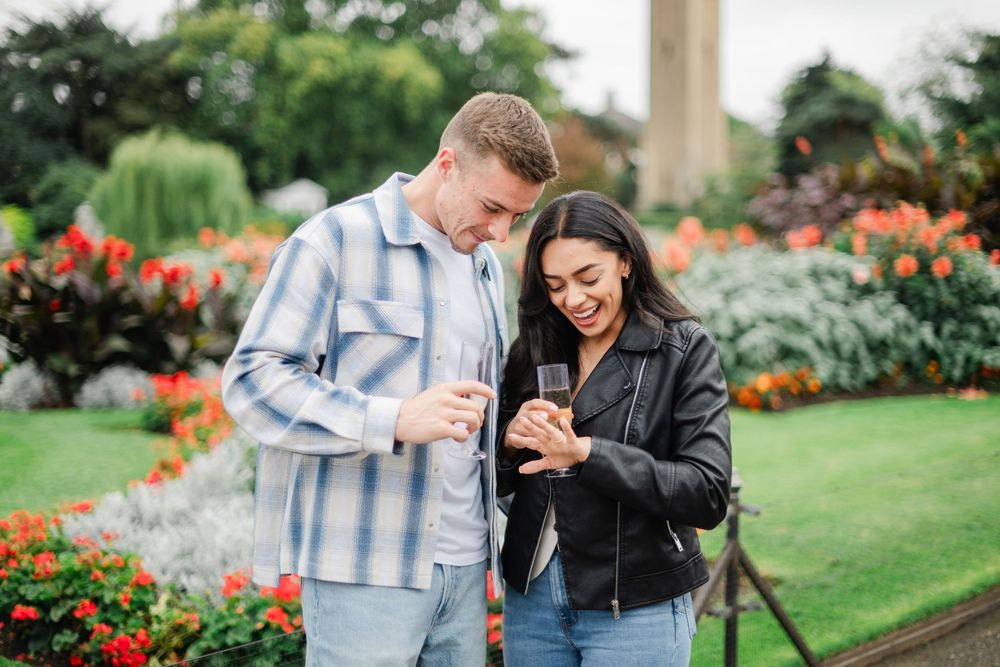 Couple enjoying a romantic moment together among vibrant flowers in a beautiful garden setting.
