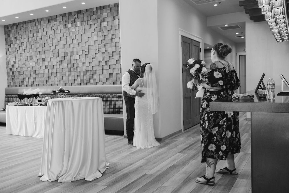 Reception guests dance and celebrate at an elegant ballroom wedding party with crystal chandeliers and white decor.