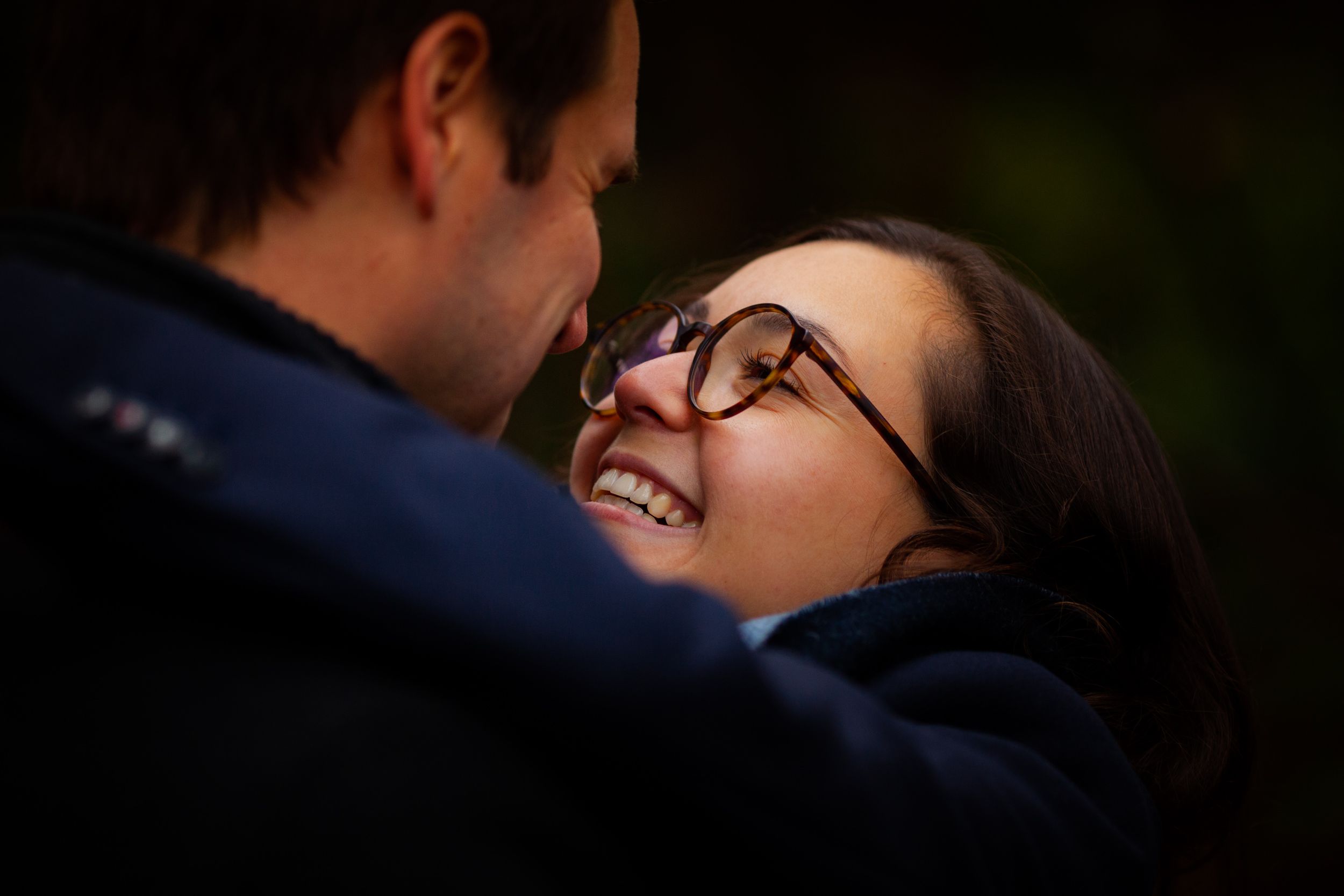 Close-up view of a romantic couple in navy blue attire sharing an intimate moment together.