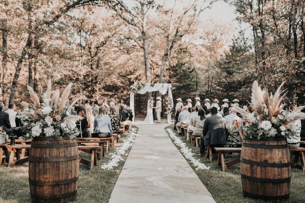Outdoor wedding ceremony at Whispering Oaks barn with rustic modern altar and elegant greenery