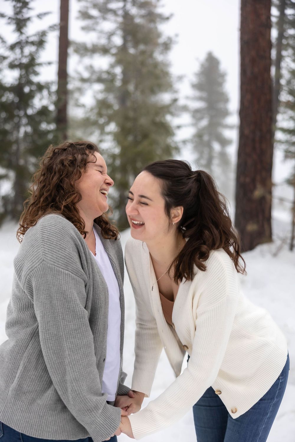 Joyful winter photoshoot showing genuine laughter and friendship in the snow.