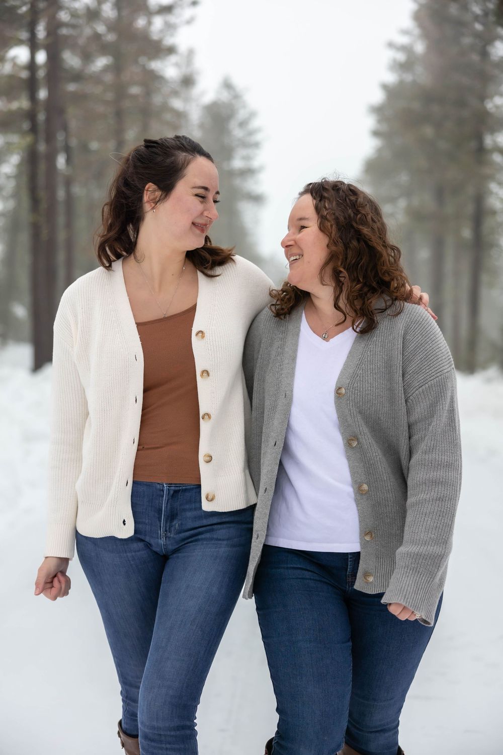 Friends in coordinating sweaters share authentic moments in a wintry forest setting.