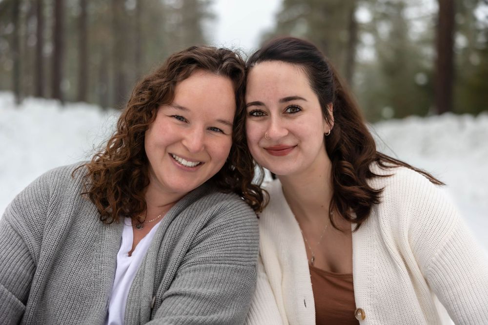 Genuine smiles and warm embraces captured during a winter forest photoshoot.