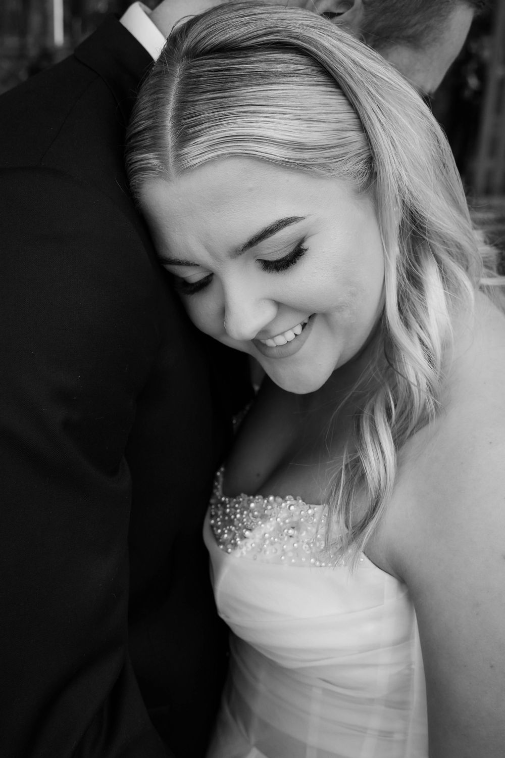 A series of black and white portraits showing close-up shots of a bride in a strapless wedding gown with beaded details.