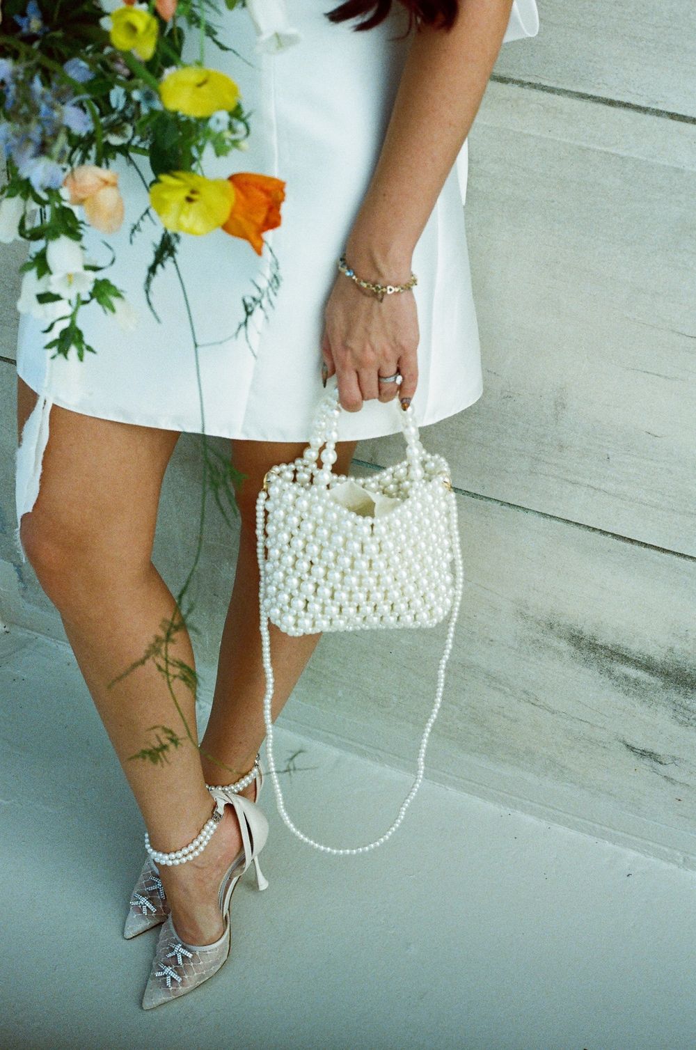 Close-up shots of elegant pearl accessories with white dress and silver heels showcasing summer fashion details.