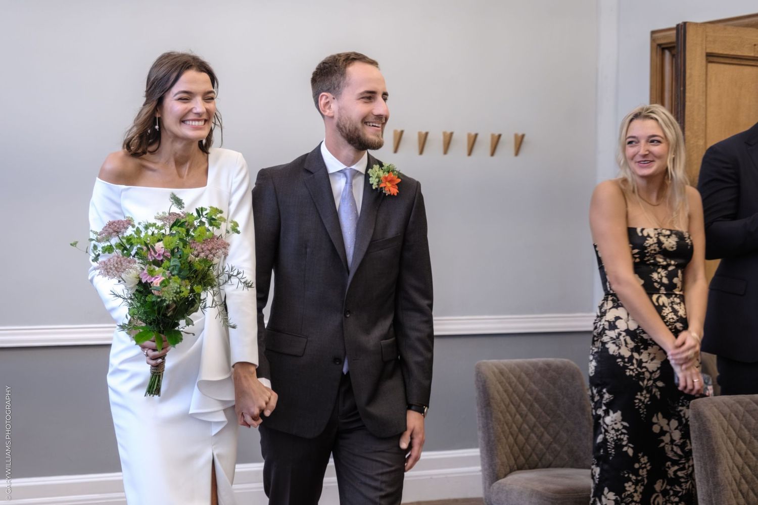 A joyful wedding scene with people sharing laughter inside a banquet hall.