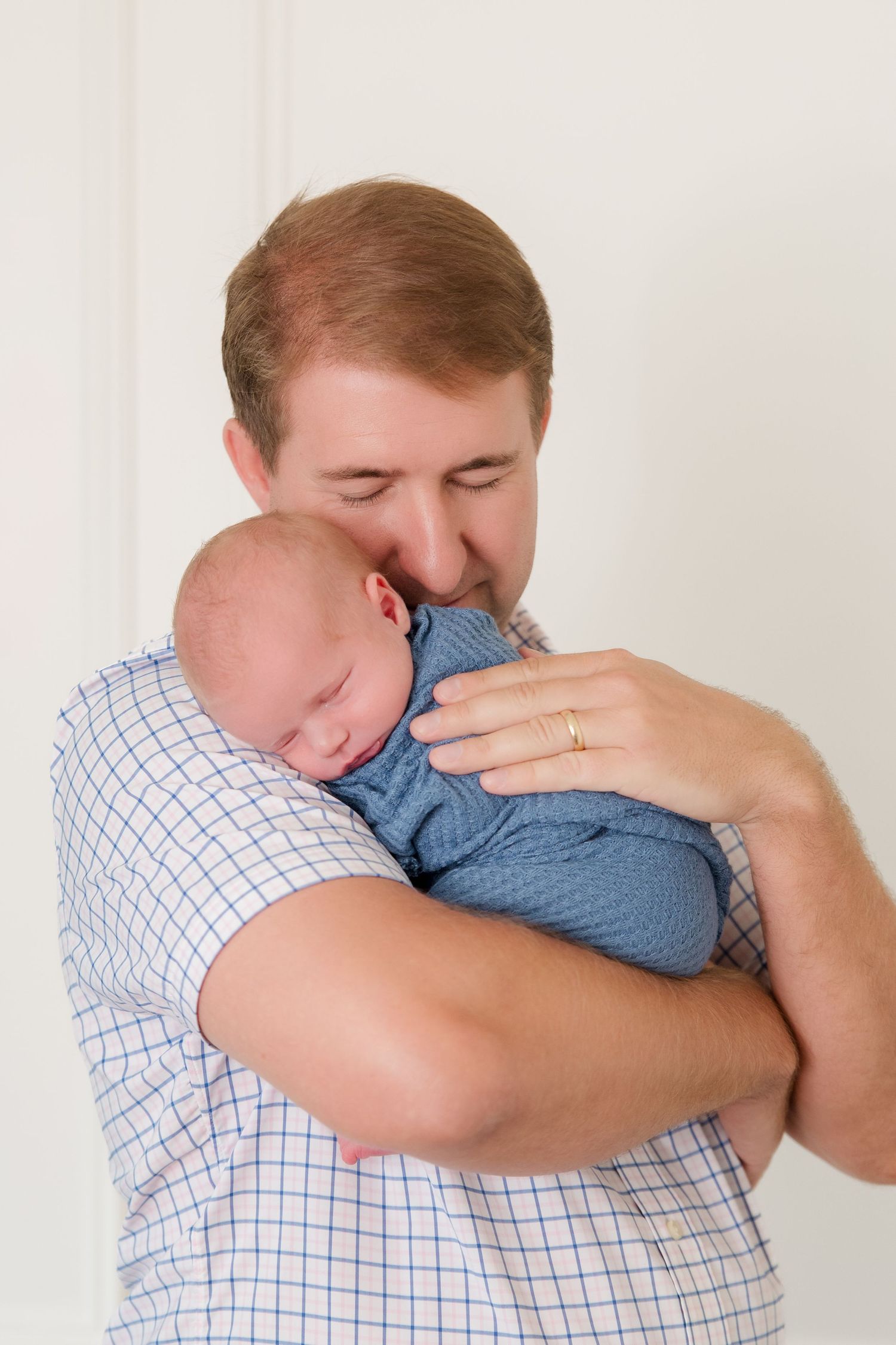 Three connected images show an emotional moment with someone holding and comforting an infant in a checkered shirt.