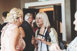 People gather and socialize at an elegant indoor event with stylish decor and soft lighting.