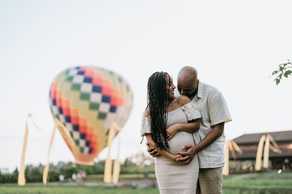 Colorful hot air balloon floats in sky during outdoor photo session.