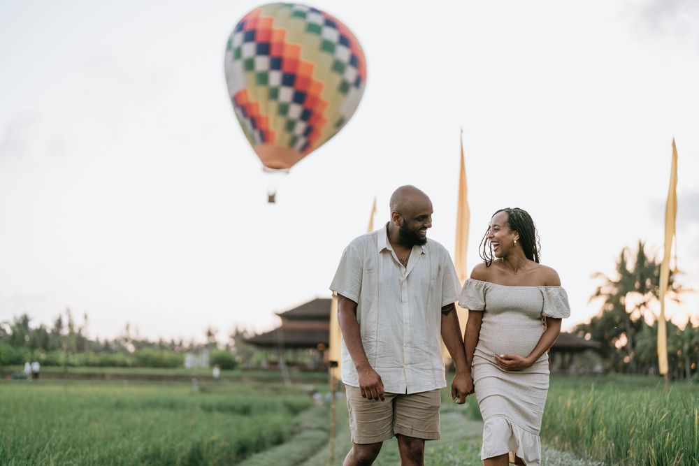Colorful hot air balloon adds whimsical touch to outdoor couple's portrait session.