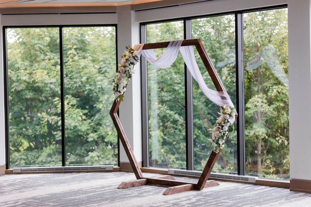 Large paneled windows overlooking trees and mountains create an expansive view in an interior space.